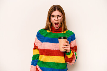 Young caucasian woman holding a take away coffee isolated on white background screaming very angry and aggressive.