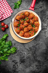 Meatballs with tomato sauce in frying pan on black background, vertical image. top view. place for text