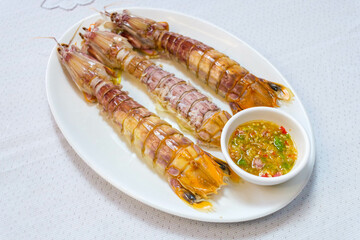 steamed crayfish or mantis shrimps on white disk with seafood sauce Thai Food