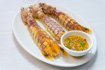 steamed crayfish or mantis shrimps on white disk with seafood sauce Thai Food