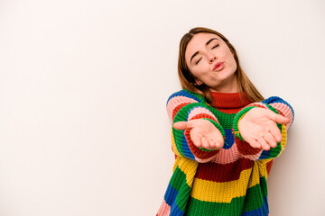 Young caucasian woman isolated on white background folding lips and holding palms to send air kiss.