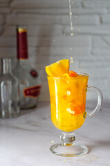 Juice from orange and sea buckthorn with ice of orange color freshly squeezed on the table, decorated with a slice of orange