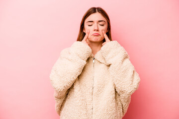 Young caucasian woman isolated on pink background crying, unhappy with something, agony and confusion concept.