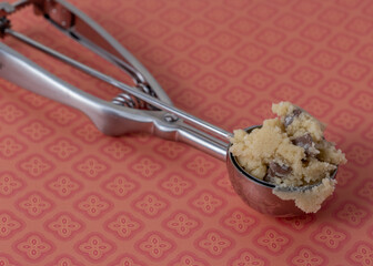 uncooked chocolate chip cookie dough in a metal scoop with space for text 