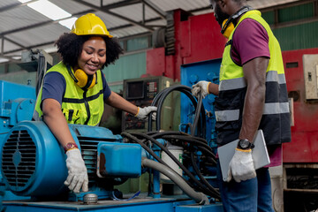 Concept of technician heavy industry, Teamwork African American engineer wear hardhat working at machine in factory. Team technician control metalwork lathe industrial.