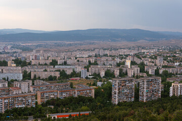 Fototapeta premium Top view from the highest point to the new and old houses, skyscrapers, city, town, and most famous park in Tbilisi is the capital of Georgia. Zghvisubani III Micro-District I Block