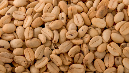 Unpeeled green dryed coffee, natural background macro view