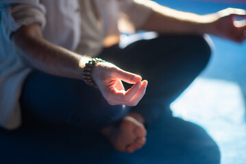 Close-up of meditating mans hands. Barefoot man sitting in lotus pose with smoke around making sign with fingers. Hobby, spirituality, health concept
