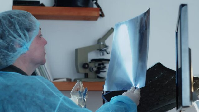 A female surgeon examines a medical history on an X-ray image of a tumor of the brain and lungs in preparation for surgery. Neurosurgery.
