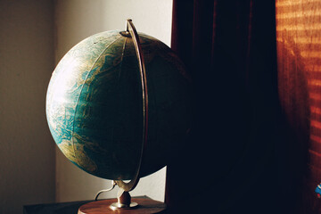 Closeup of a globe on the wooden table in the room