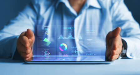 Businessman holding tablet with growing virtual hologram of statistics, graph and chart.Chart graph...