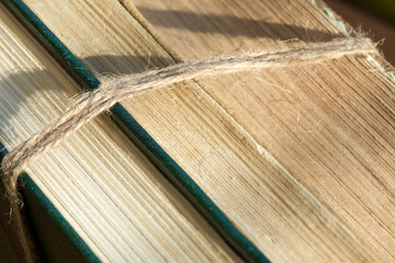 A stack of ancient books tied with twine.