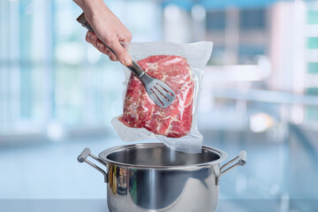 Cooking meat vacuum packed with sous-vide technology. - obrazy, fototapety, plakaty