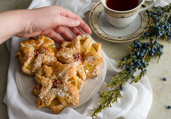 Delicious baked puff pastry and cup of tea. Hand taking desert 