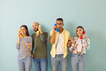 Diverse people talk on landline phones with customer support or call center. Multiracial people clients speak on corded telephones, give opinion or feedback. Isolated on green studio background.