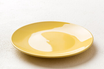 Perspective view of empty yellow plate on cement background. Empty space for your design