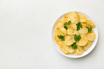 Potato chips on bowl with napkin on colored background. Delicious crispy potato chips in bowl. Space for text. Top view