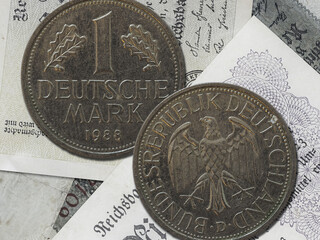 Top view of the front and back of a historic West Germany deutsche mark coin on a paper background