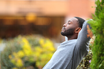 Relaxed man with black skin resting in a park - 494011703
