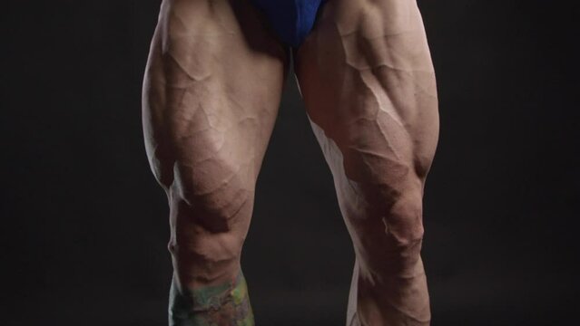 Close-up of a bodybuilder strains leg muscles