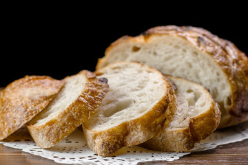 Close up of slices of freshly homemade wheat bread on napkin on table, selective focus.