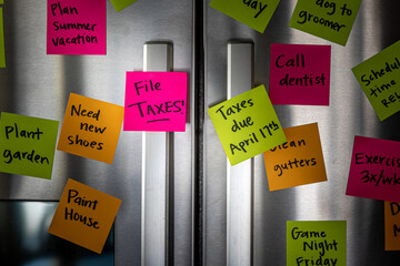 Close Up of Fridge Door With Reminder Notes Reminding to File Taxes April 17th
