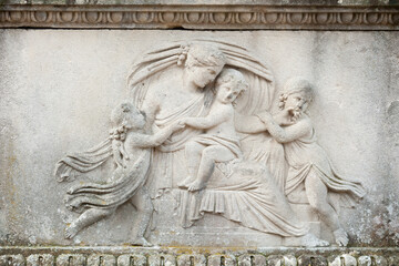 Bas-relief of a young woman embracing her children