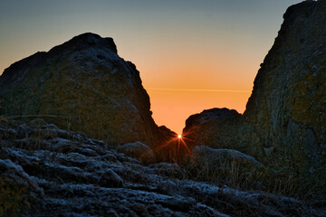 Sun peaking between two rocks at winter solstice