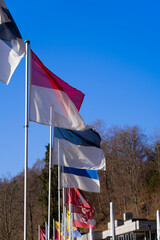 Flags of all Swiss Cantons at border of natural pool of famous Rhine Falls on s sunny spring day. Photo taken March 5th, 2022, Zurich, Switzerland.