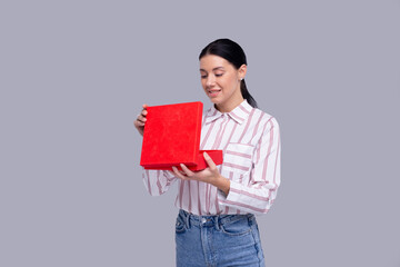 Fototapeta premium Girl Holding Present Watching Whats inside. Girl Holding Gift. Surprise. Isolated