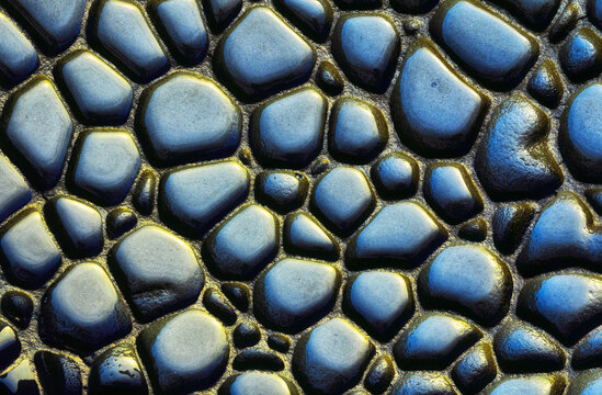 Wet cobblestone road as textured background