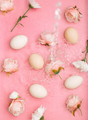 Fototapeta na wymiar Easter scene with rose flowers and eggs in water with bubbles. Minimal natural pastel pink background.