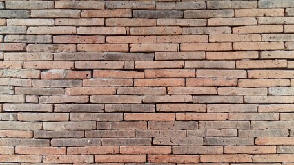 Fototapeta premium Brick wall background is a wall made of clay bricks, giving the structure strength and cement line between bricks that looks beautiful. It is popular to build a wall of ancient monuments.copy space,