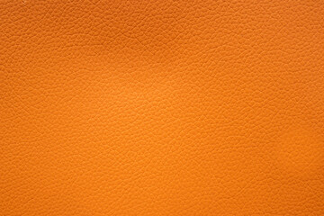 Orange faux leather background is used to wrap book covers or to repair everyday leather sofa seats...
