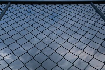Smooth focus and dark, steel mesh background is used to make a high fence to block unauthorized entry to the area to ensure the safety of people inside and prevent the loss of property.