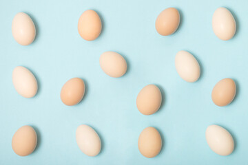 Creative layout made with natural color eggs. Minimal easter pattern on pastel blue background. Spring holidays concept.