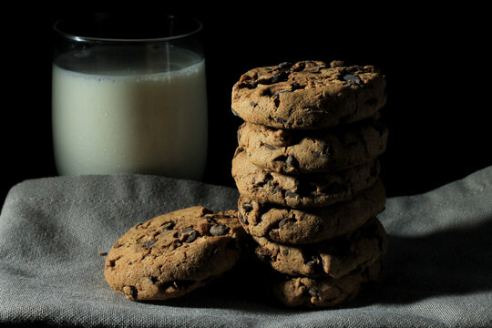 Closeup Shot Of Chocolate Chip Cookies On Top Of A Gray Cloth And Glass Of Milk