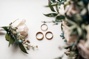 Wedding rings lie with fresh flowers