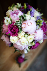 Wedding rings lie on a bouquet of flowers