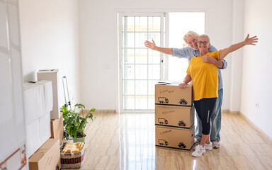 Smiling caucasian senior couple white haired open arms looking at camera during relocation, happy...