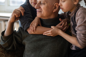 Obraz premium Ukrainian grandfather and two granddaughters hugging