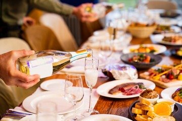 a man pours champagne into a glass. sparkling wine for a party. the tradition of toasting and drinking alcohol on holidays.