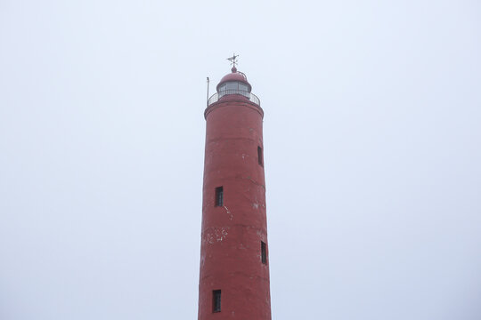 Old red lighthouse near Baltic sea in Latvia, called Akmensraga lighthouse.