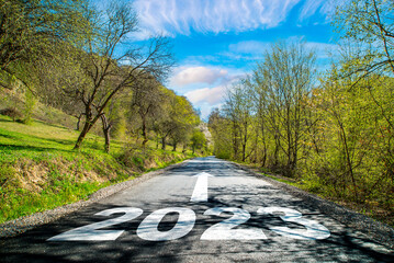 road 2023. Spring landscape near the road in the woods .on the asphalt road written 2023 in front....