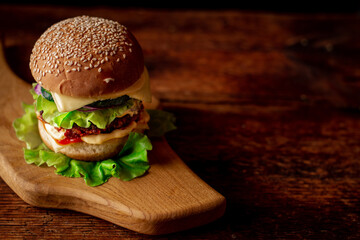 Hamburger wooden curly board. Dark wooden background. Hamburger day.