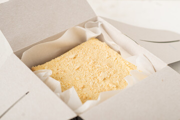 Napoleon cake in a cardboard box. Sweet gift. Delivery of confectionery.