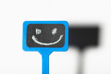 A sign with a smiley face. Blue wooden poster with a positive smile on a white background.