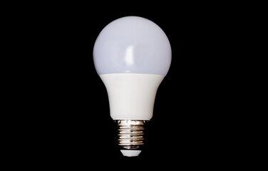 Round modern LED lamp with a metal base with a plastic housing isolated on a black background