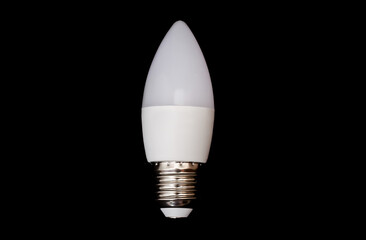 A small pointed modern LED lamp with a metal base with a plastic housing isolated on a black background