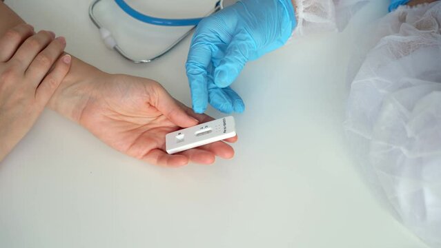 Top view of doctor gives rapid antigen test for covid-19 to female patient in clinic. Quick swab method to coronavirus. PCR